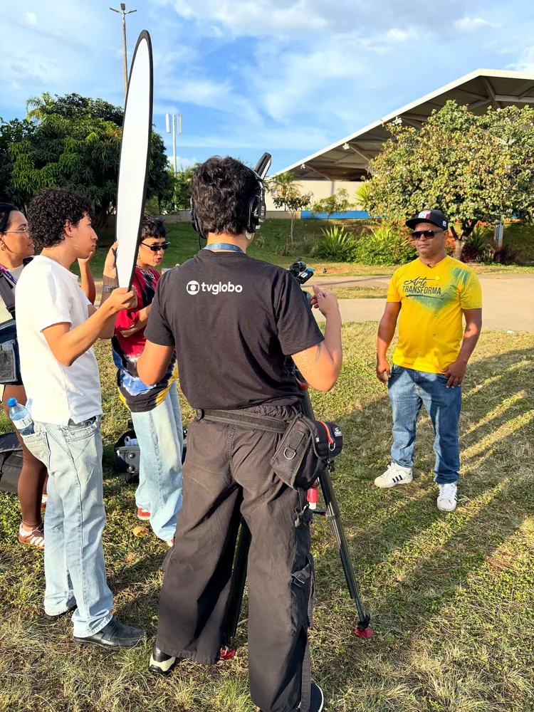 Equipe de TV entrevistando pessoas em um evento ao ar livre sobre a cena do grafite