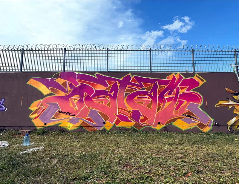 Letras em estilo wild-style pintadas em muro a céu aberto